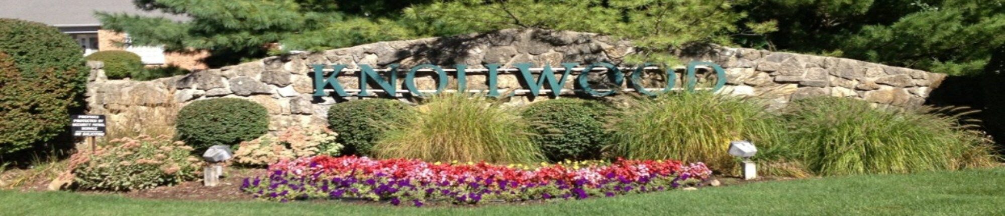 A sign that is in front of some flowers.