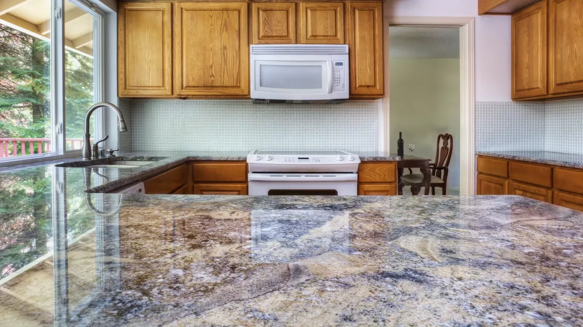 granite counter reflecting kitchen cabinets