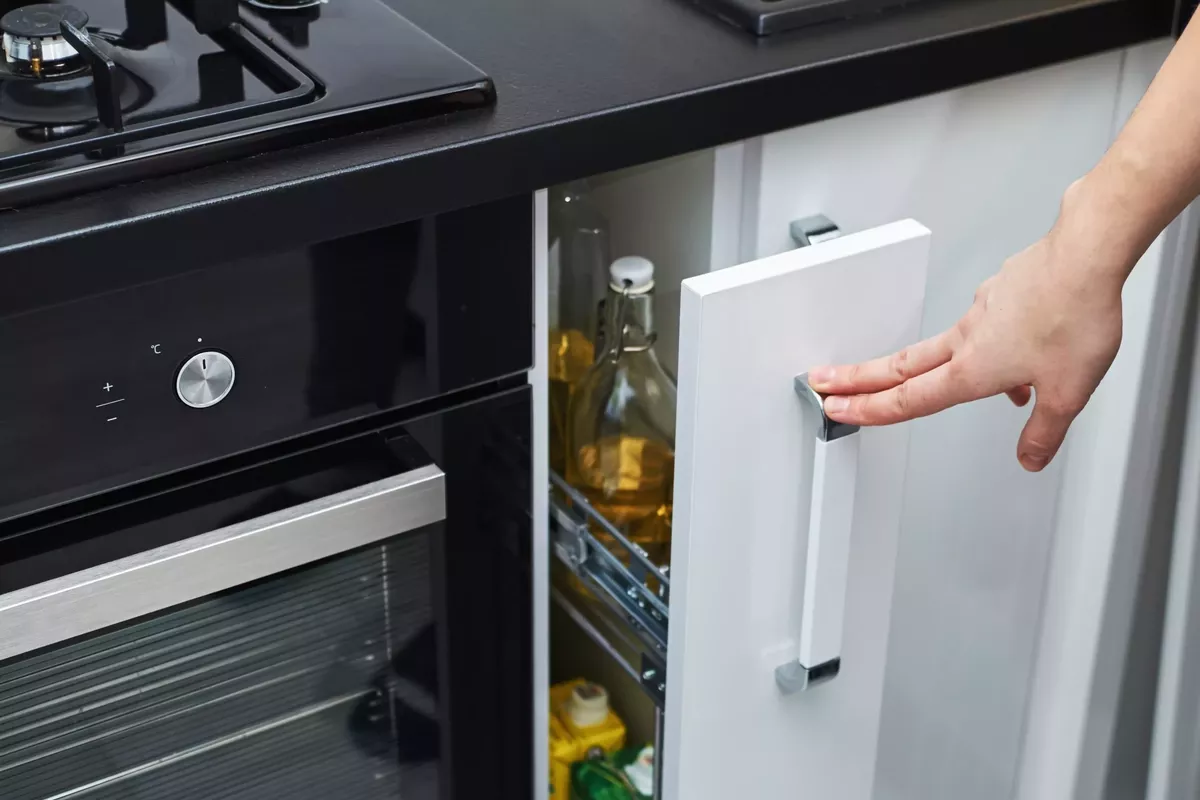 woman hand open a kitchen storage cabinet