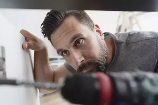 carpenter installing hinges in a cabinet